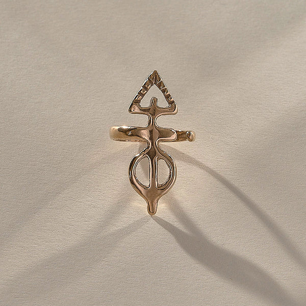 Gold ring with a unique design on a beige fabric background