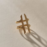 Akash Shield Statement Ring in solid recycled gold at an angle, showing the carved shield bars and open design.