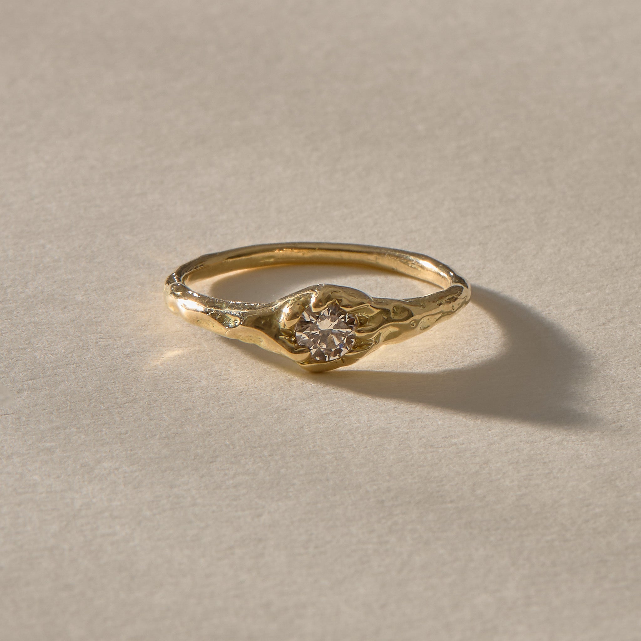 Ama Champagne Diamond Ring in gold at an angle, showing the delicate band and diamond setting.