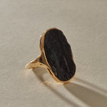 Black Tourmaline Amulet Ring XIX at an angle, showing the raw stone texture and gold setting.