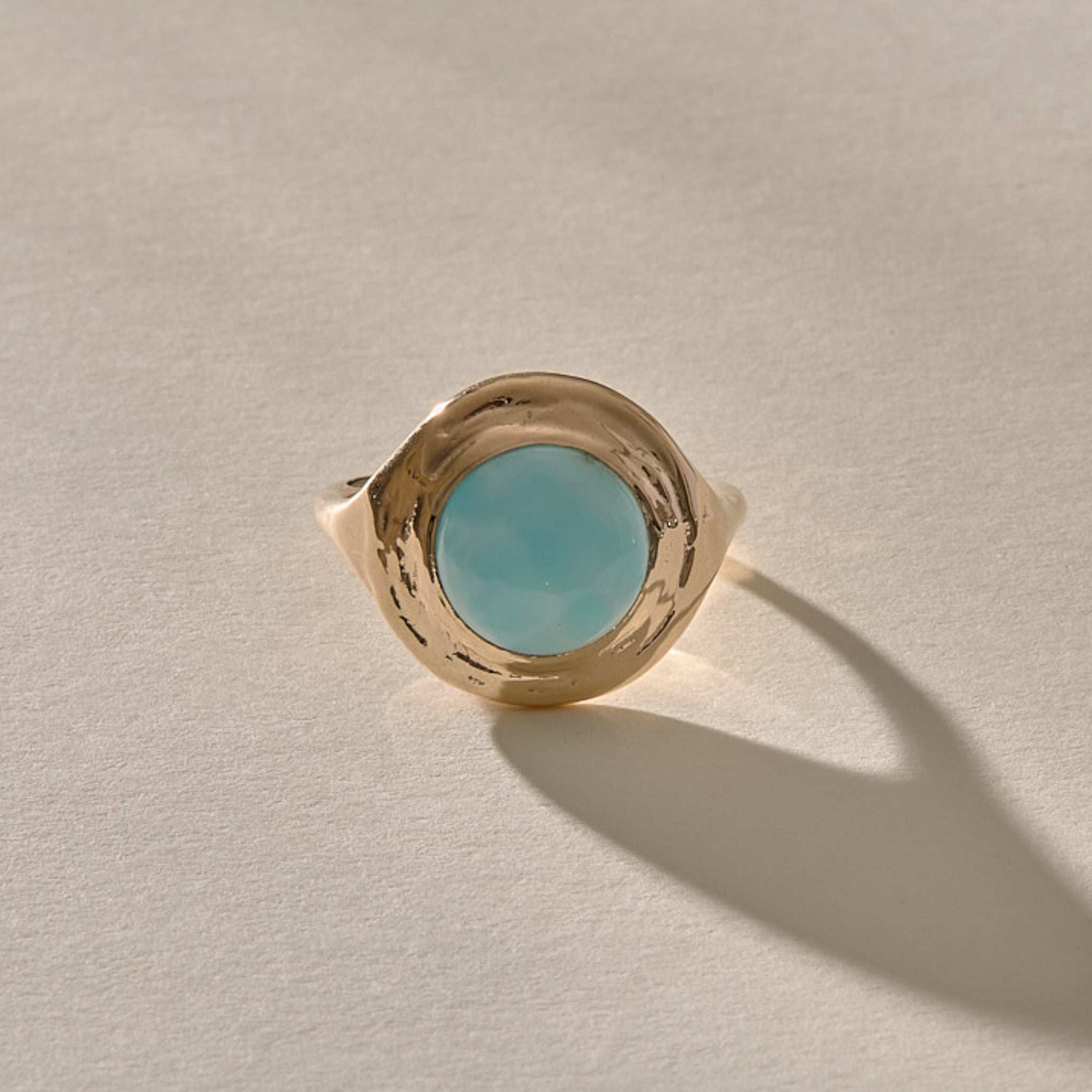 Elysian Larimar Signet Ring in solid recycled gold from the front, a round blue larimar stone in a textured signet setting.