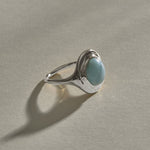 Elysian Larimar Signet Ring in recycled sterling silver at an angle, showing the round blue larimar cabochon.