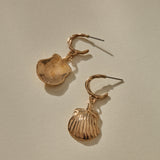 Elysian Shell Hoop Earrings in bronze, one shell turned to show its smooth inside.