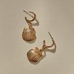 Elysian Shell Hoop Earrings in bronze laid flat, showing the ribbed scallop shells and slim hoops.