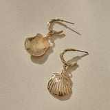 Elysian Shell Hoop Earrings in gold, one shell turned to show its smooth inside.