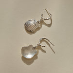 Elysian Shell Hoop Earrings in sterling silver, one shell turned to show its smooth inside.
