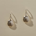 Elysian Shell Hoop Earrings in sterling silver, a pair of ribbed scallop shells catching the light.