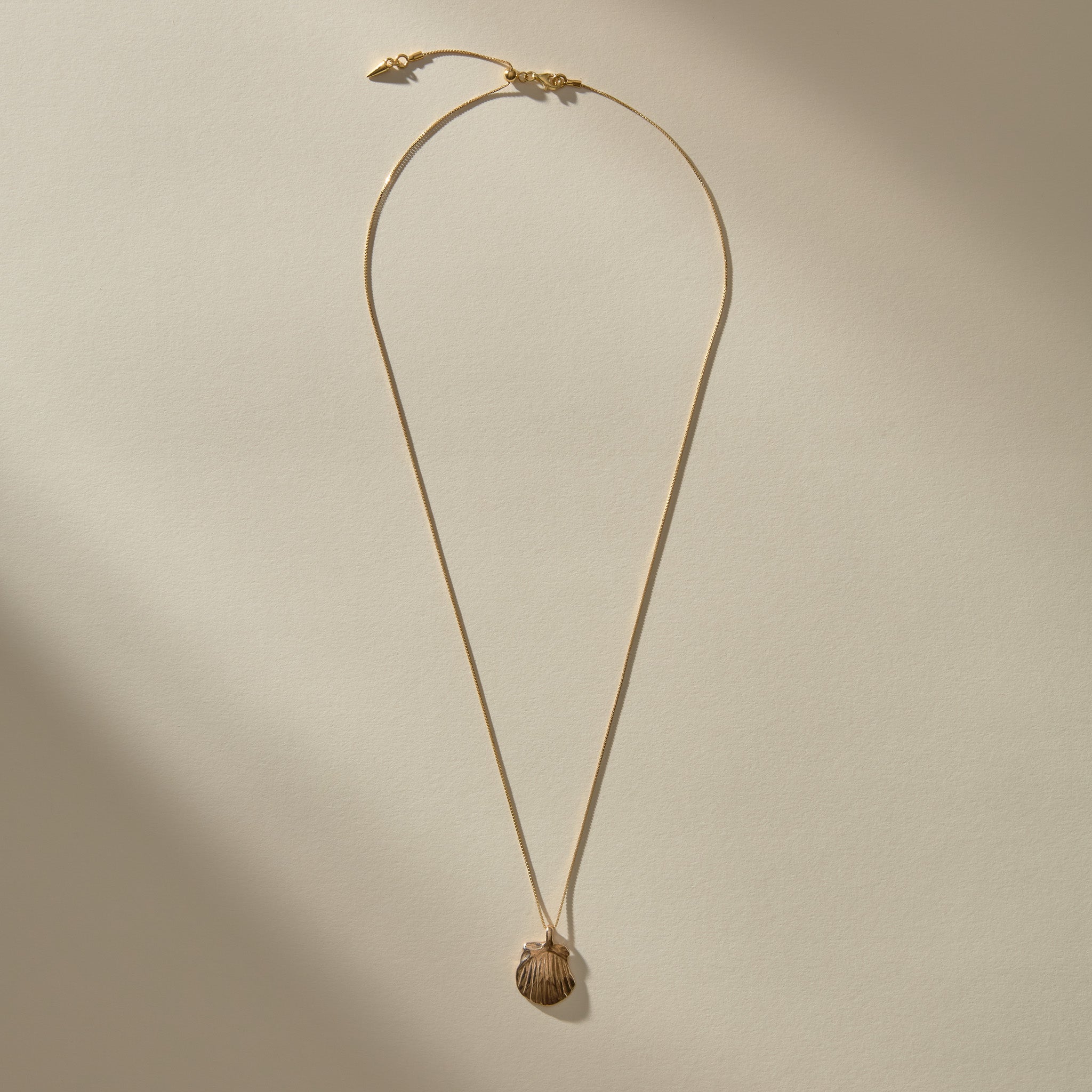Full length of the Elysian Shell Necklace in bronze on its adjustable box chain.