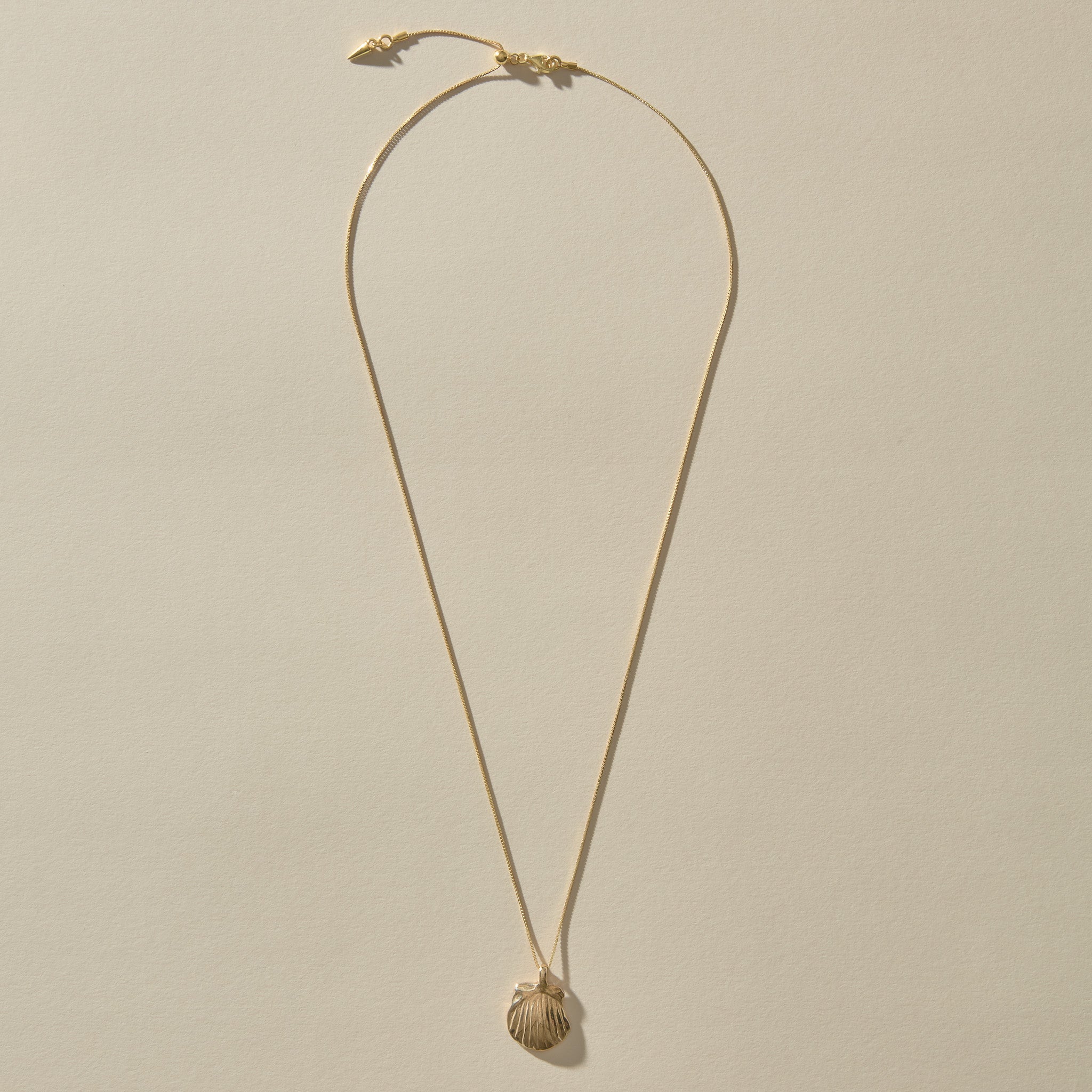 Full length of the Elysian Shell Necklace in gold on its adjustable chain.