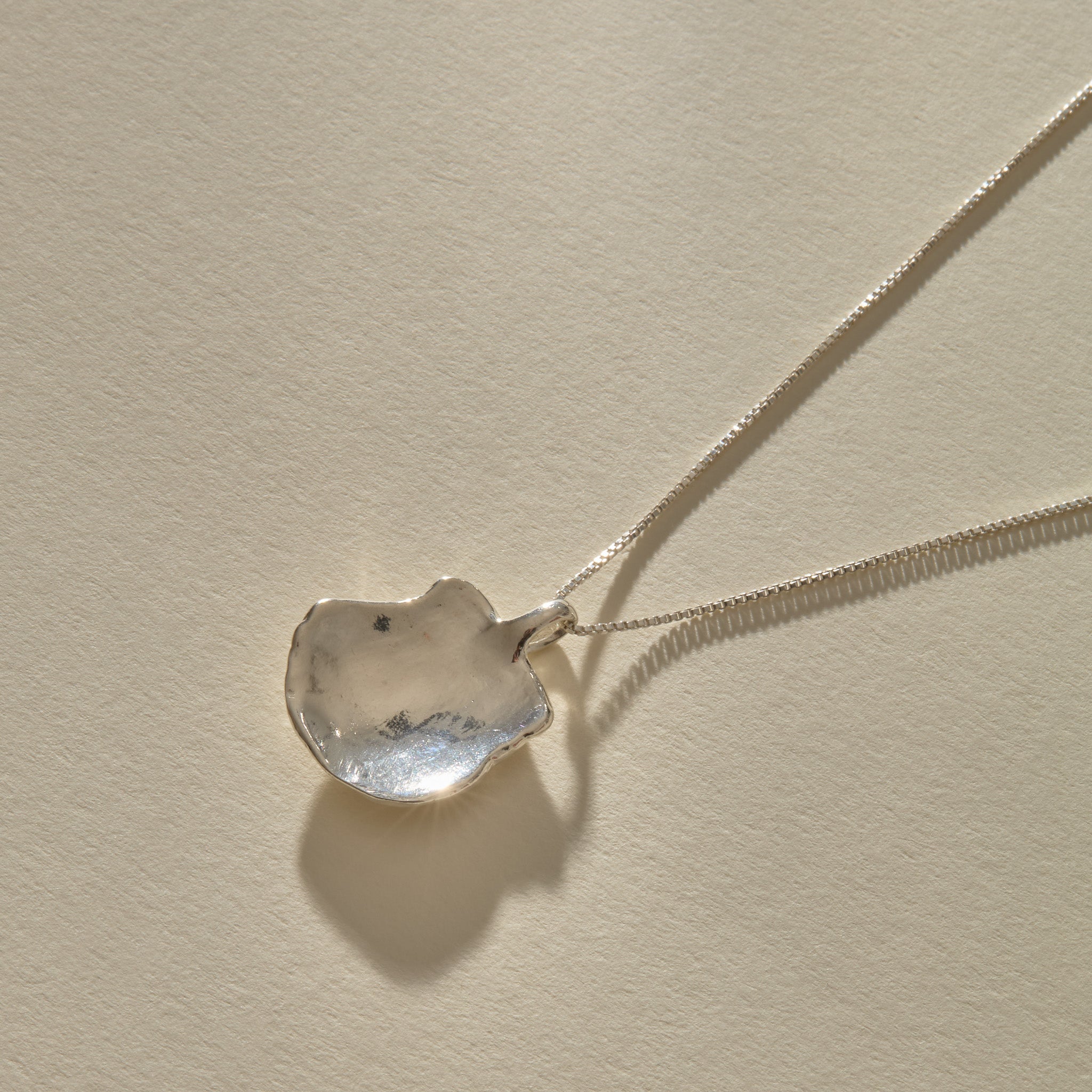 Back of the Elysian Shell Necklace pendant in sterling silver, showing the smooth inside of the shell.