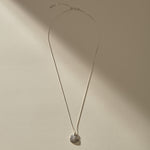 Full length of the Elysian Shell Necklace in sterling silver on its adjustable box chain.