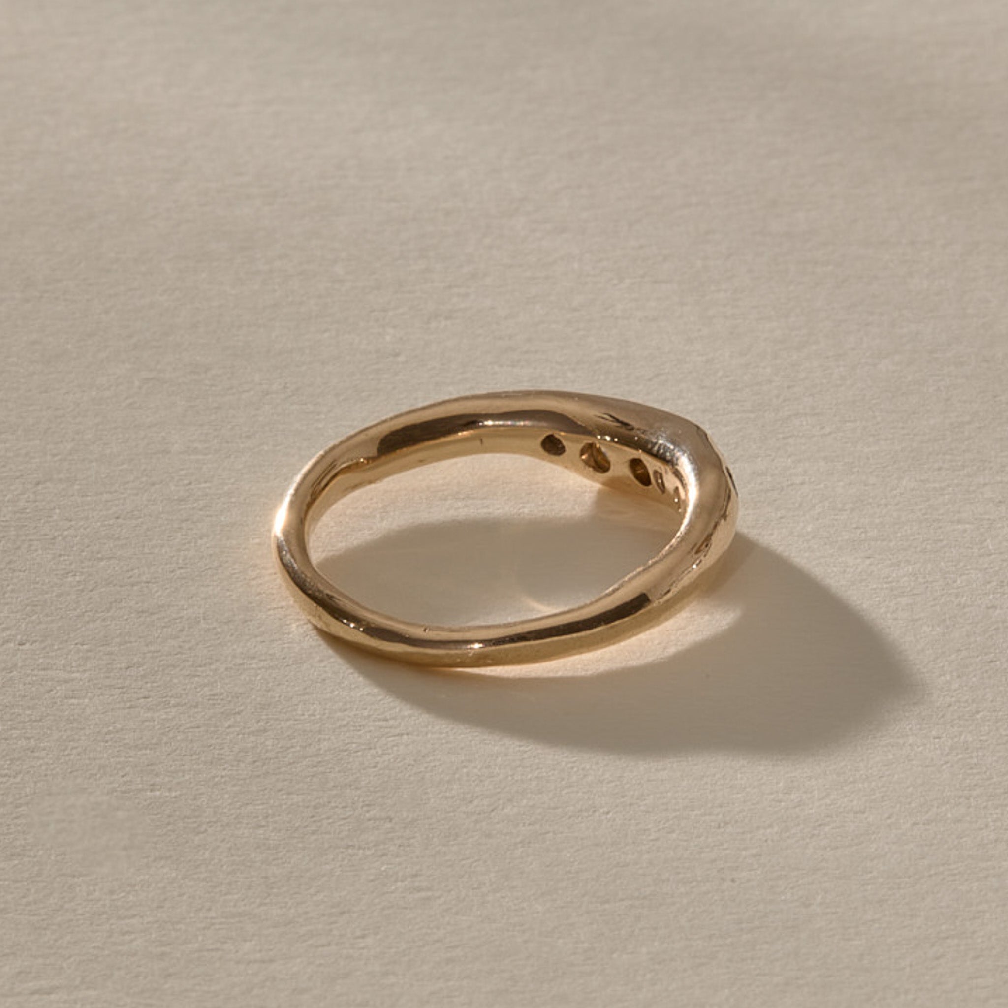 Eros Five-Stone Champagne Diamond Band in solid recycled gold from the back at an angle, showing the smooth inner band.