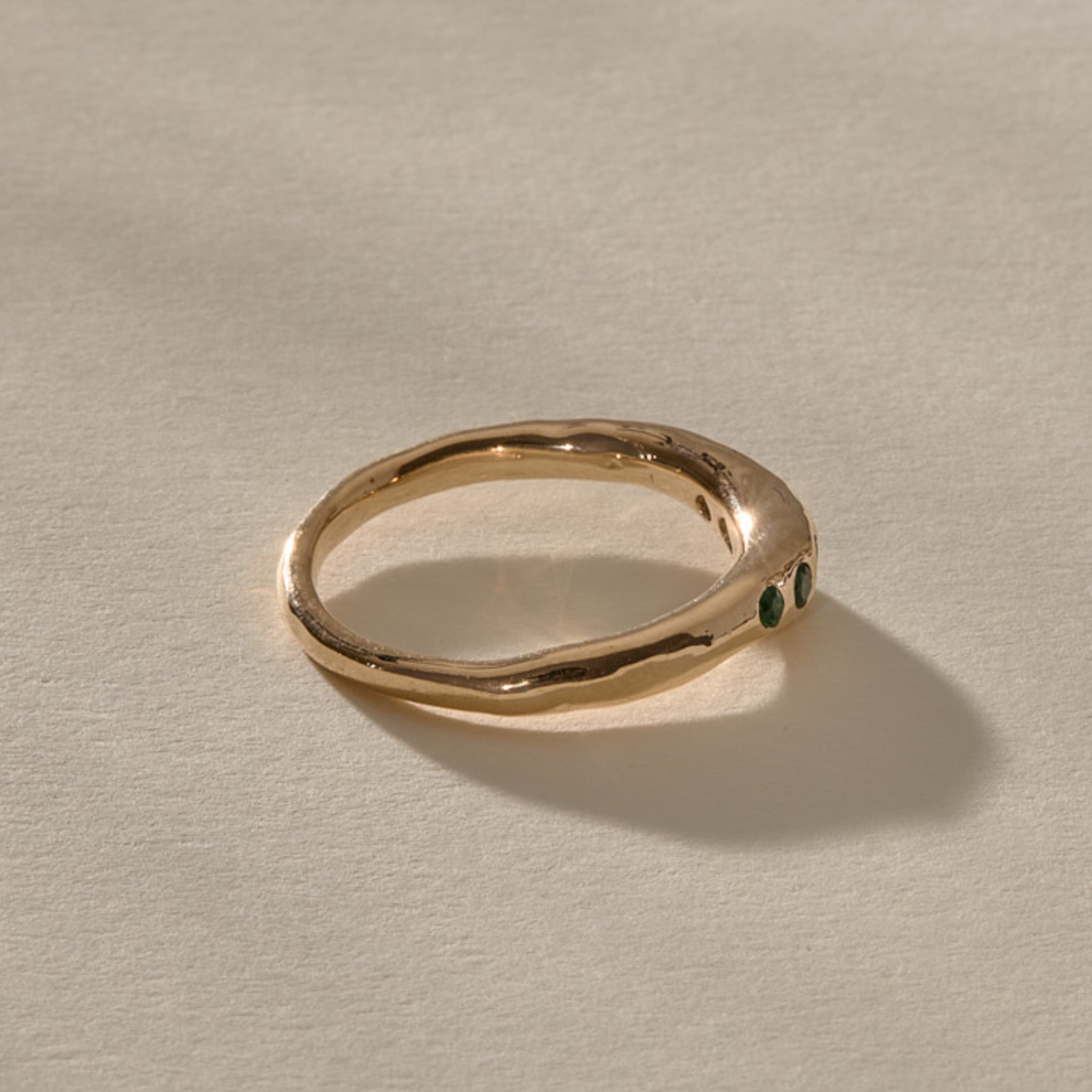 Eros Five-Stone Emerald Band in solid recycled gold from the side, showing the smooth organic band.