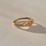 Evil Eye Protection Ring in solid recycled gold at an angle, showing the carved protective eye.