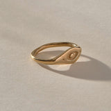 Evil Eye Protection Ring in solid recycled gold at an angle, showing the carved protective eye.
