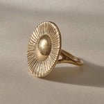 Heart of the Sun Statement Ring in solid recycled gold at an angle, showing the round sunburst face.