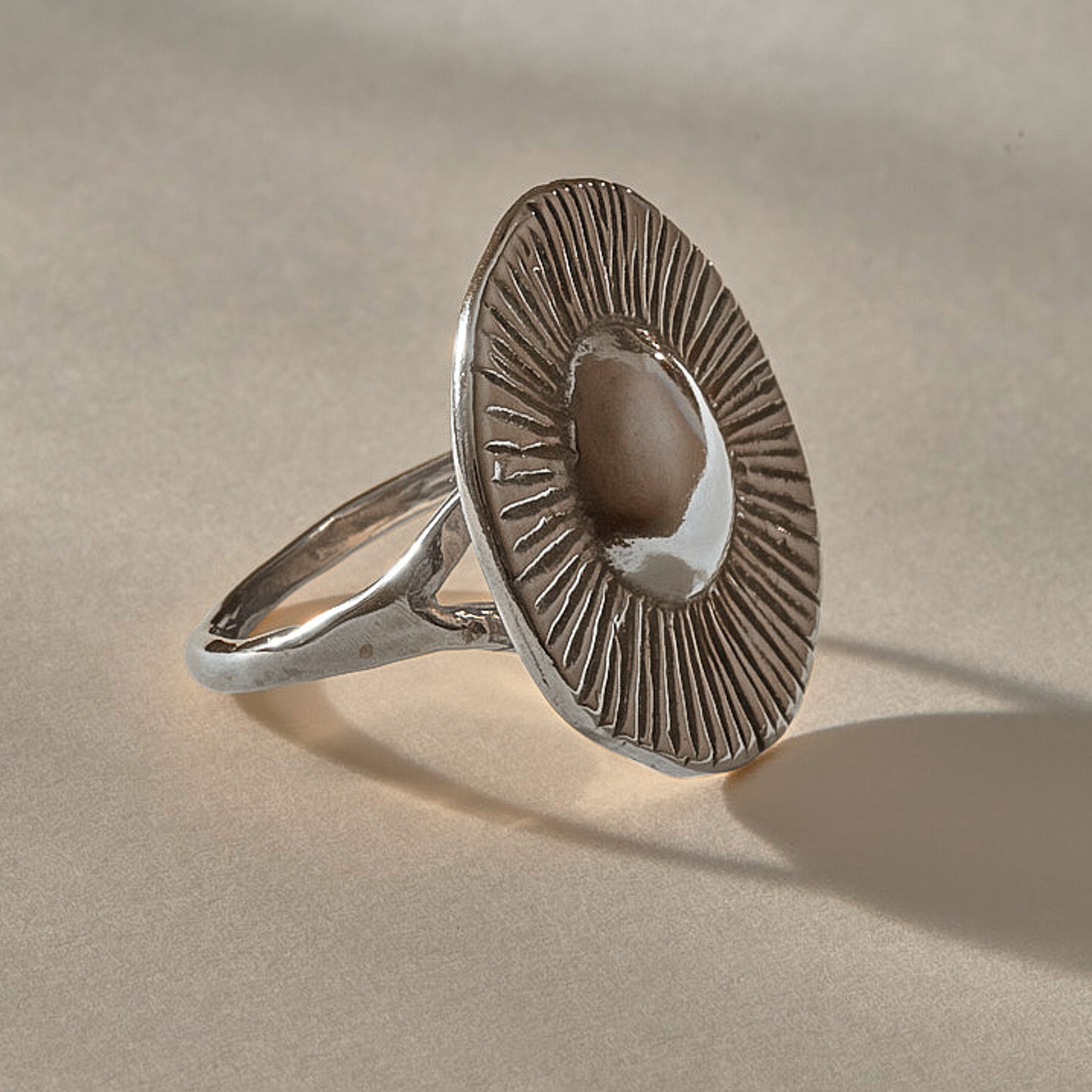 Heart of the Sun Statement Ring in recycled sterling silver from the side, showing the sunburst face and slim band.