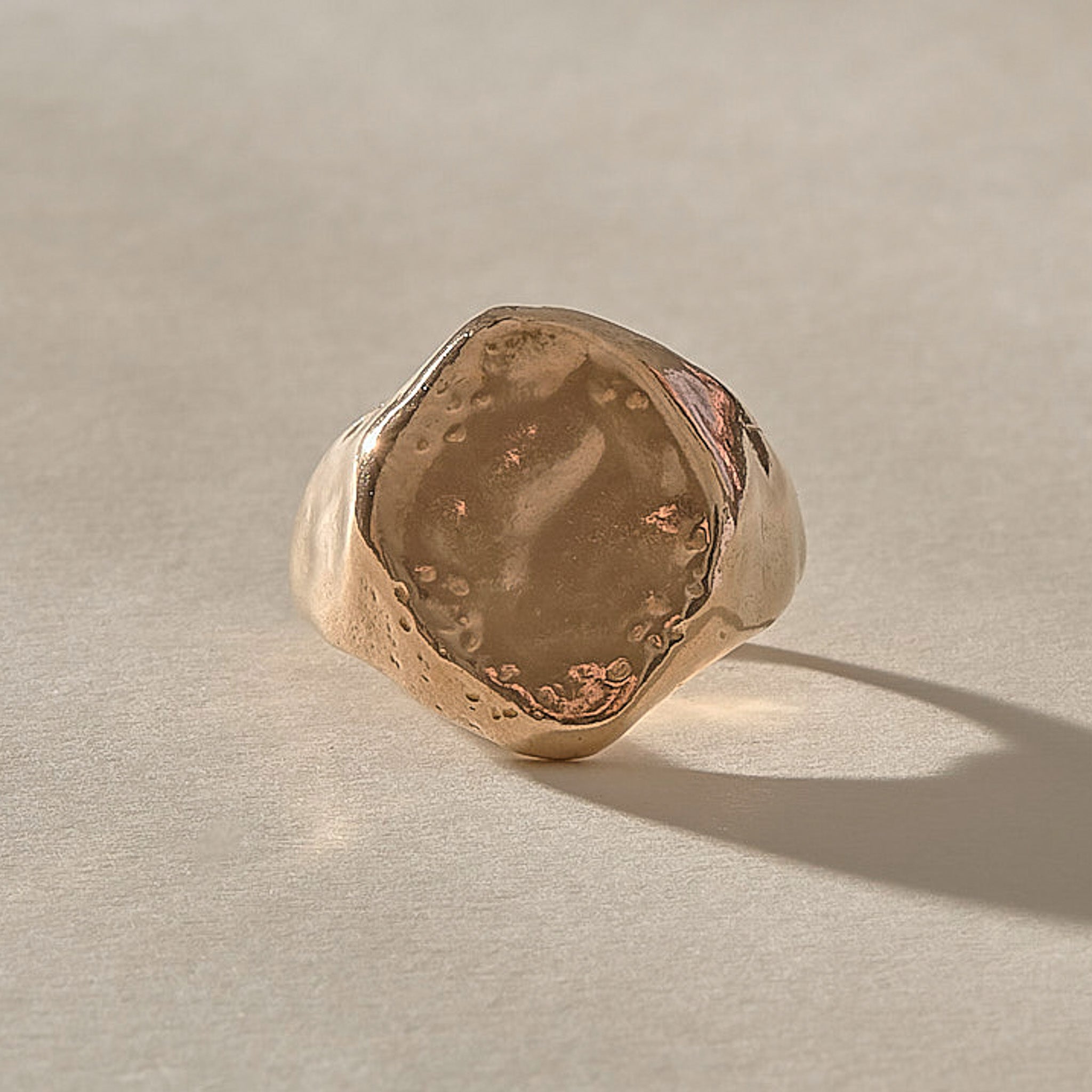 Heritage Textured Signet Ring in recycled bronze from the front, a softly indented, dappled oval face.