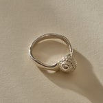 Maré Shell Ring in sterling silver at an angle, showing the textured shell and hand-formed band.
