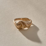 Neptune Spiral Shell Ring in recycled bronze, a hand-cast spiral seashell set on a wavy organic band.