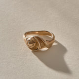 Neptune Spiral Shell Ring in recycled bronze, a hand-cast spiral seashell set on a wavy organic band.