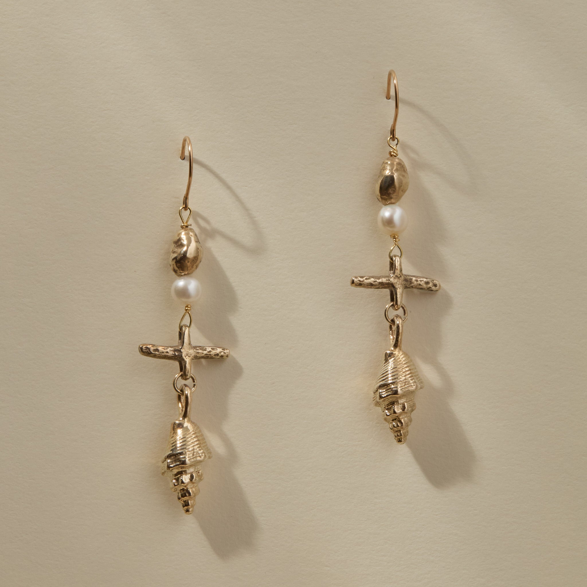 Sereia Shell and Pearl Chandelier Earrings in gold hanging side by side, showing each tier of the drop.