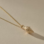 Sereia Spiral Shell Necklace in gold, the shell pendant lying on its rolo chain.