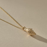 Sereia Spiral Shell Necklace in gold, the shell pendant lying on its rolo chain.