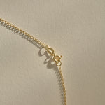 Full length of the Sereia Spiral Shell Necklace in gold on its 20 inch chain.