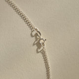 Clasp and rolo chain of the Sereia Spiral Shell Necklace in sterling silver.