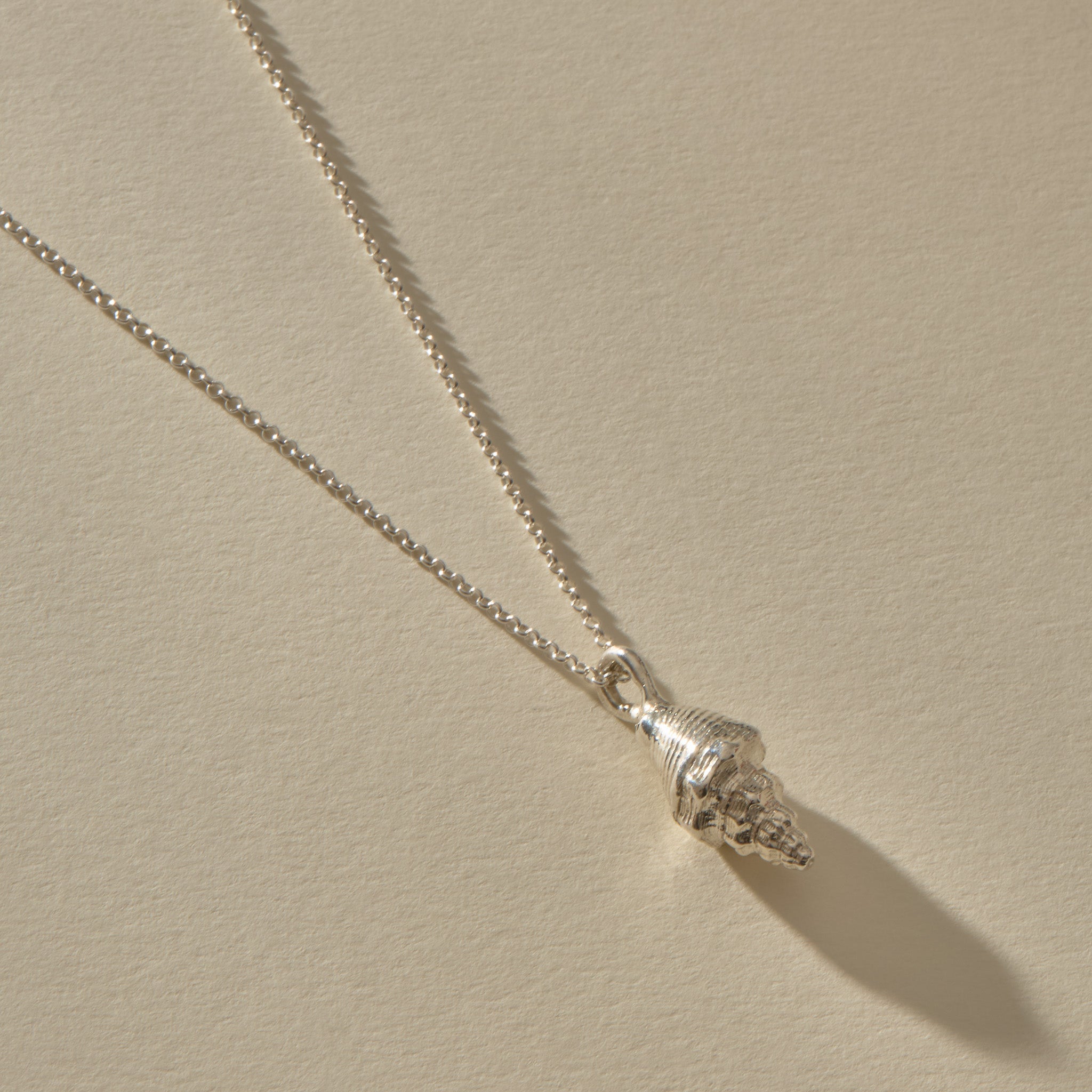 Sereia Spiral Shell Necklace in sterling silver, the spiral shell pendant at an angle.