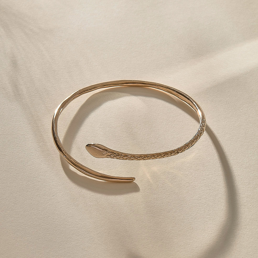Serpent Snake Arm Cuff in bronze from above, the snake wrapping around in an open spiral.