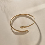 Serpent Snake Arm Cuff in gold at an angle, showing the coiled, open design.