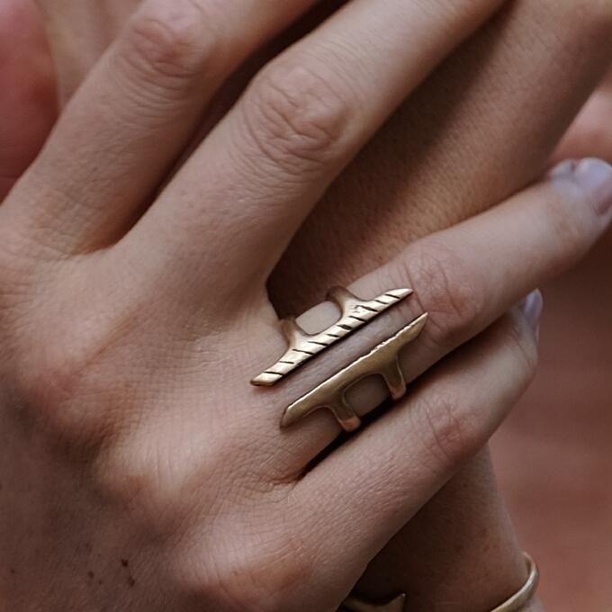 Hand wearing the Akash Shield Statement Ring across the fingers.