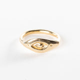 Evil Eye Protection Ring in solid recycled gold on a white background, a carved eye set into an organic band.