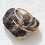 Serpent Snake Arm Cuff coiled around a dark stone, the snake head resting on top.